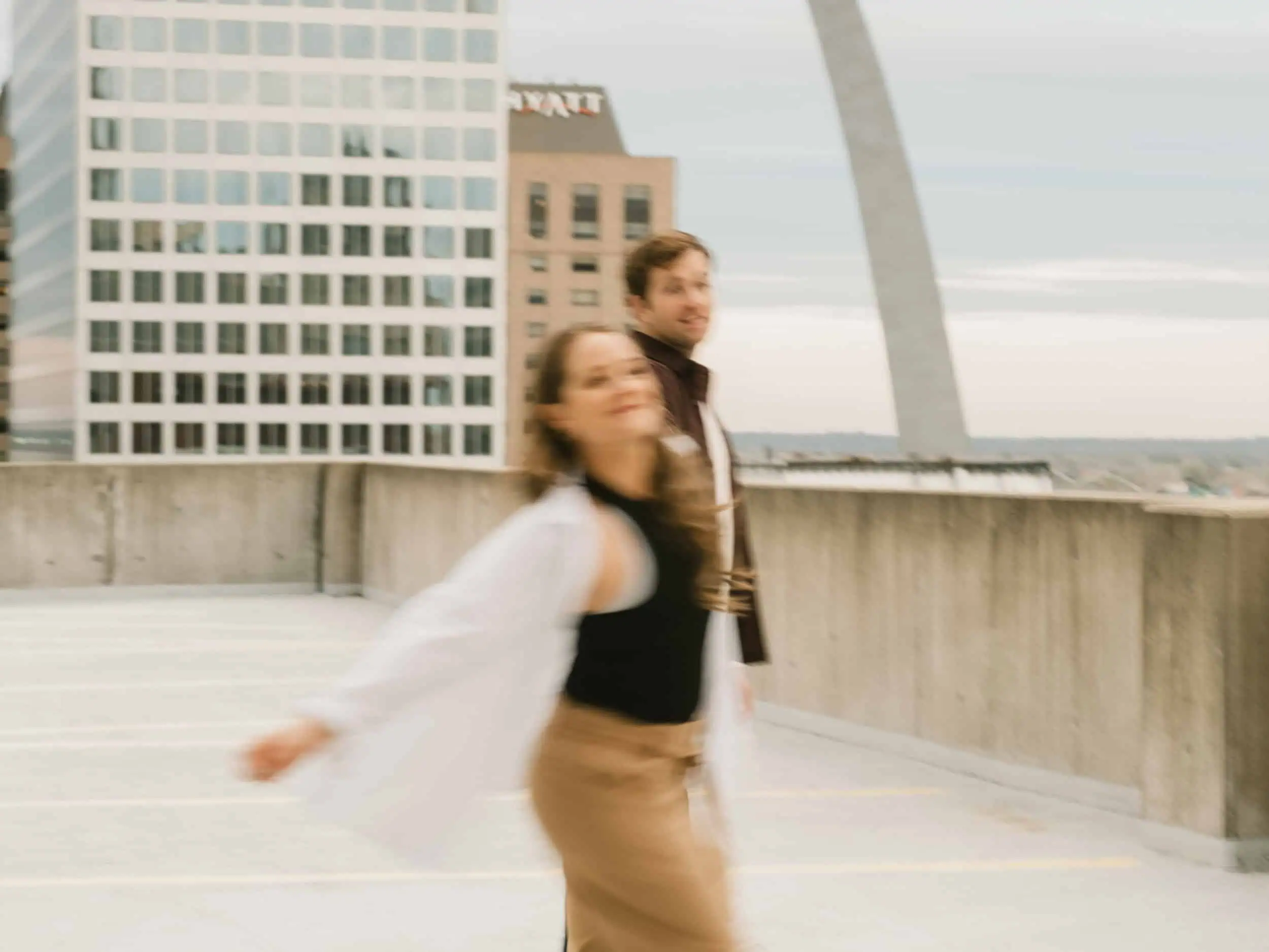 A couple spinning and dancing on a rooftop in downtown St. Louis, Missouri with motion blur and a film style.