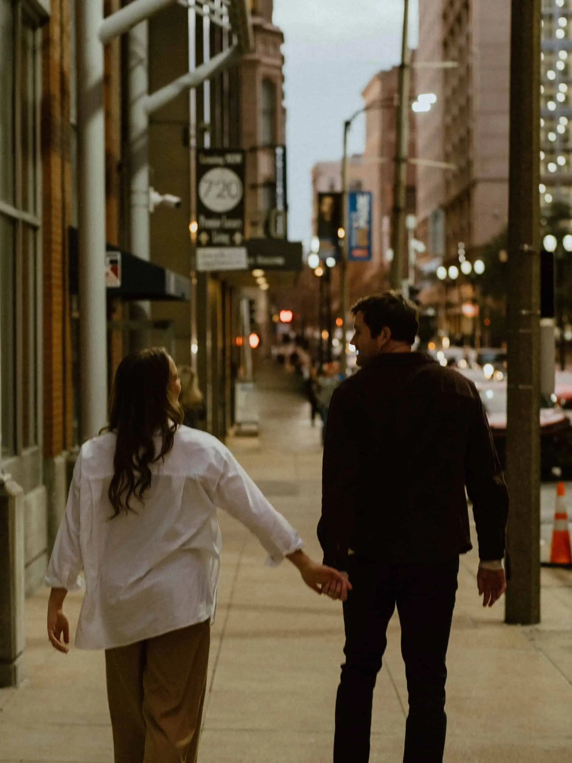 A couple walking down an urban street in St. Louis, Missouri, photographed with a romantic and moody style.