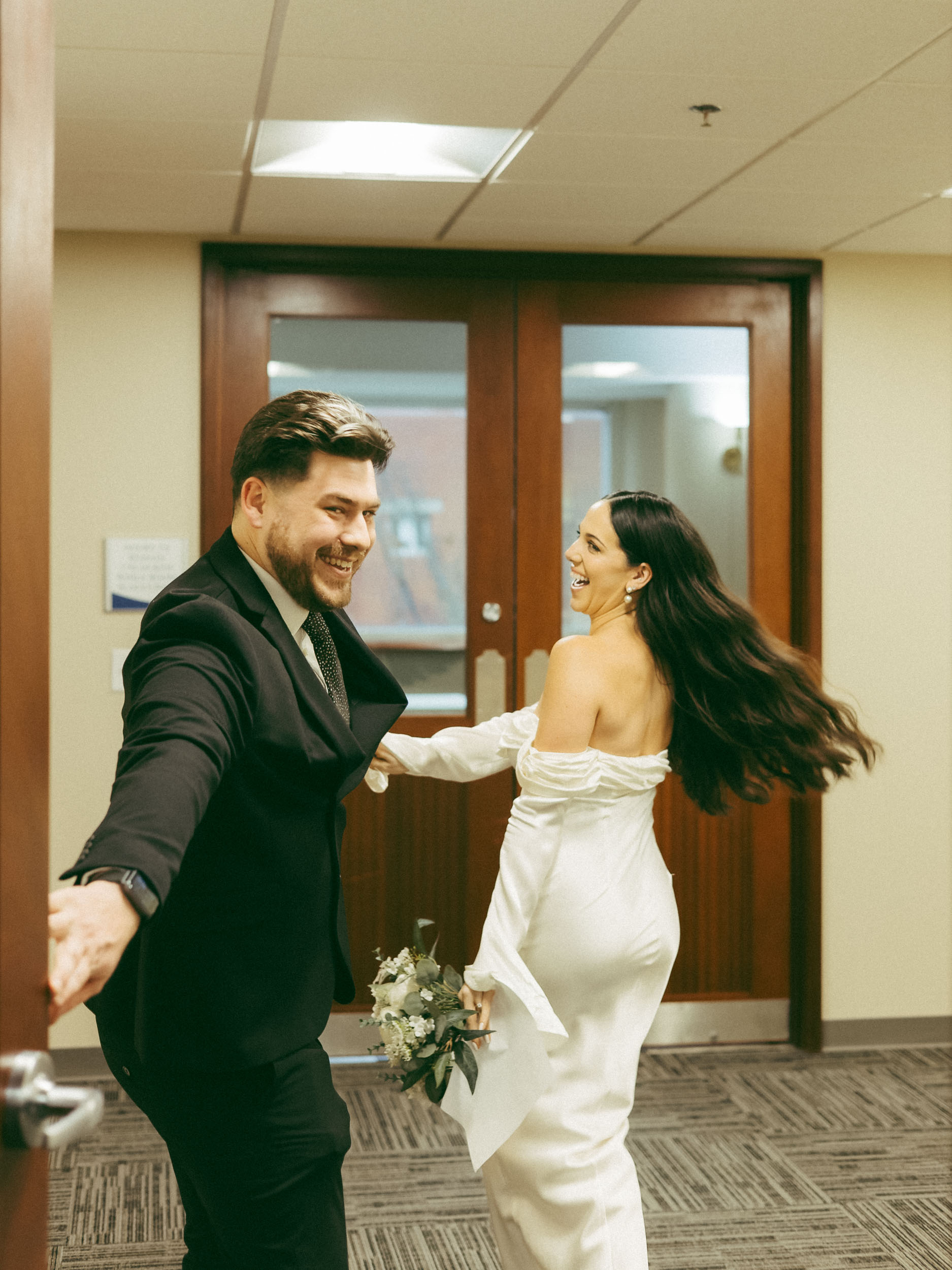 A couple laughs and smiles during their city hall elopement.