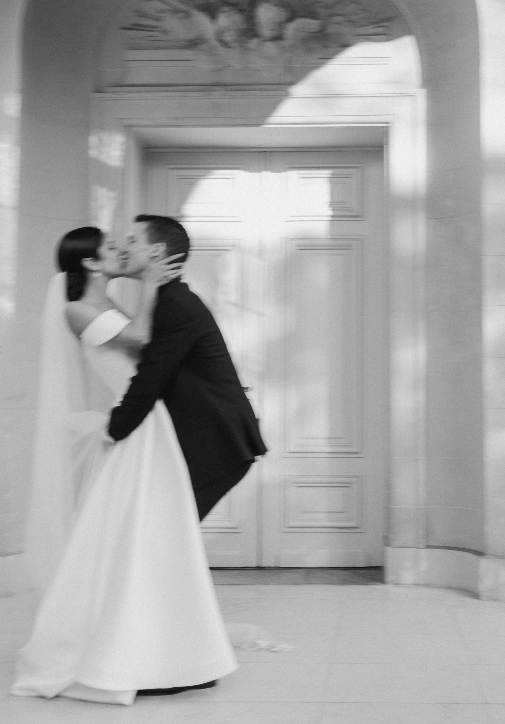 A bride and groom kiss in a documentary-style motion blur wedding photo.