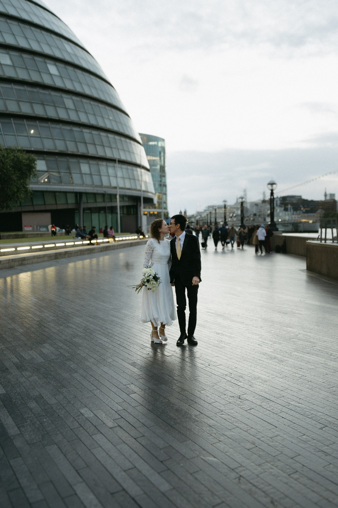 A couple kisses on the Queen's Walk during a London elopement.