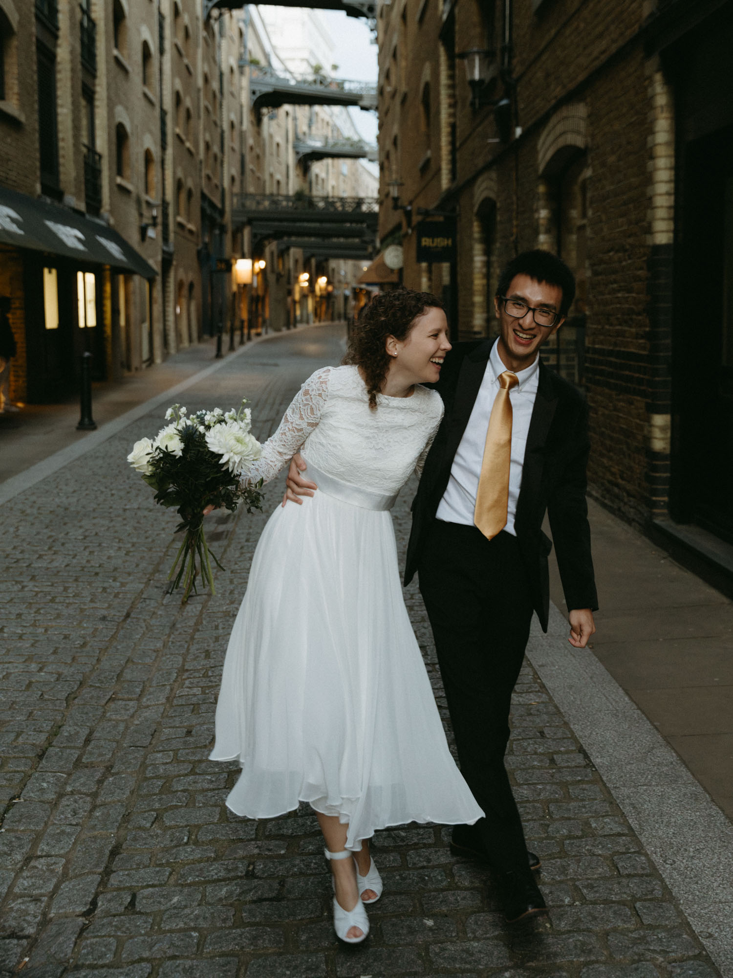 A couple eloping in London and walking through Shad Thames.