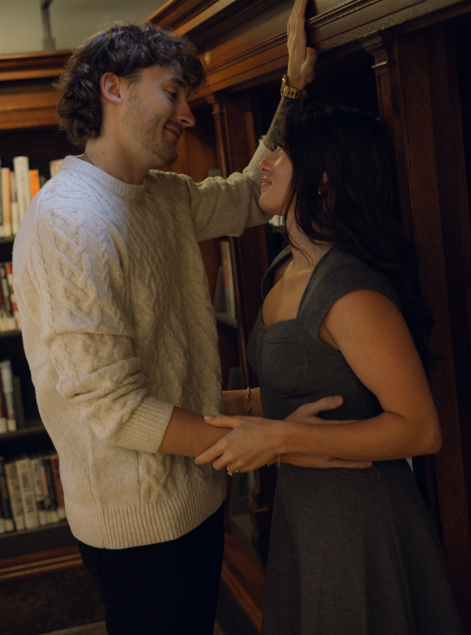 A couple in a moody library photoshoot.