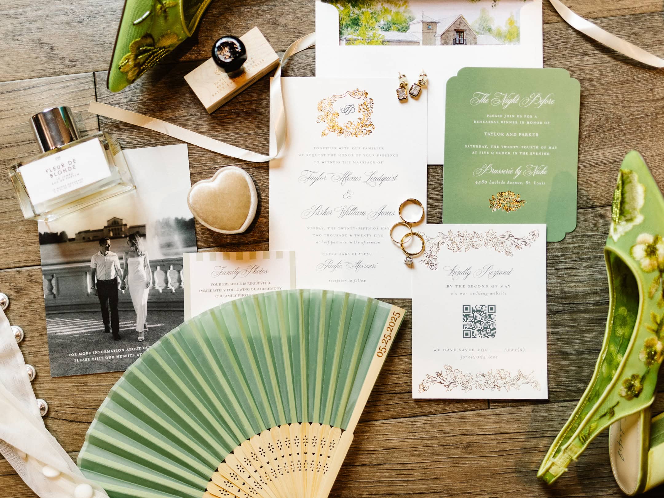 A flatlay photo of a green and ivory wedding invitation suite with a paper fan favor and green shoes.
