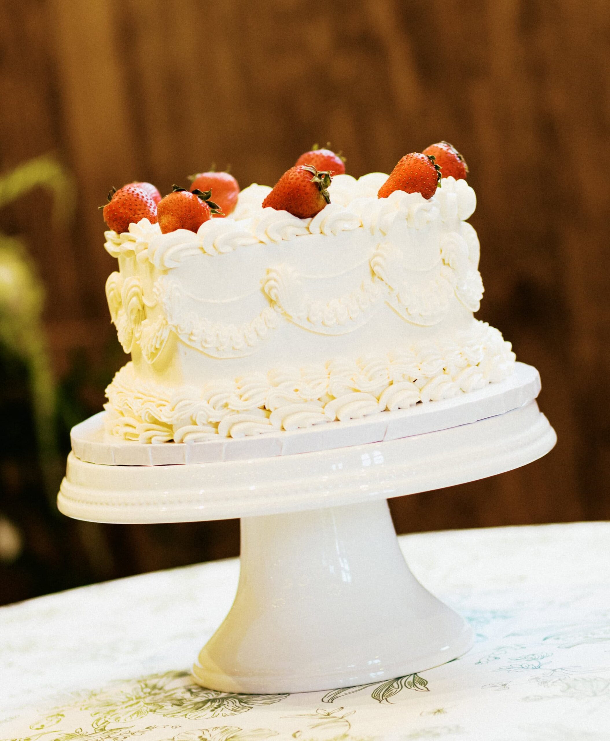 A heart shaped wedding cake with strawberries on top.