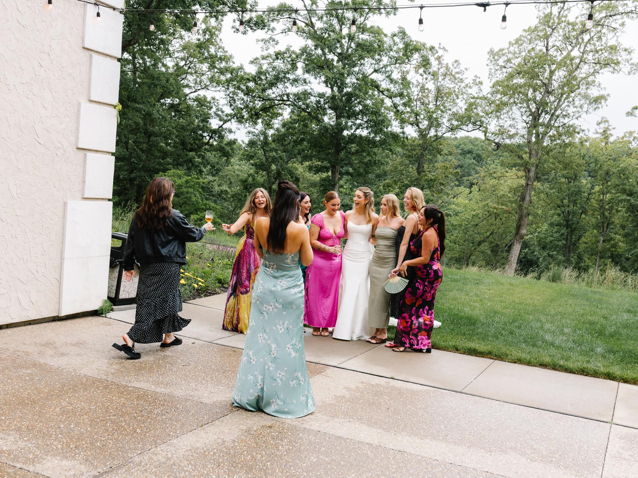 A bride poses with her friends at her outdoor wedding venue in St. Louis, Missouri.