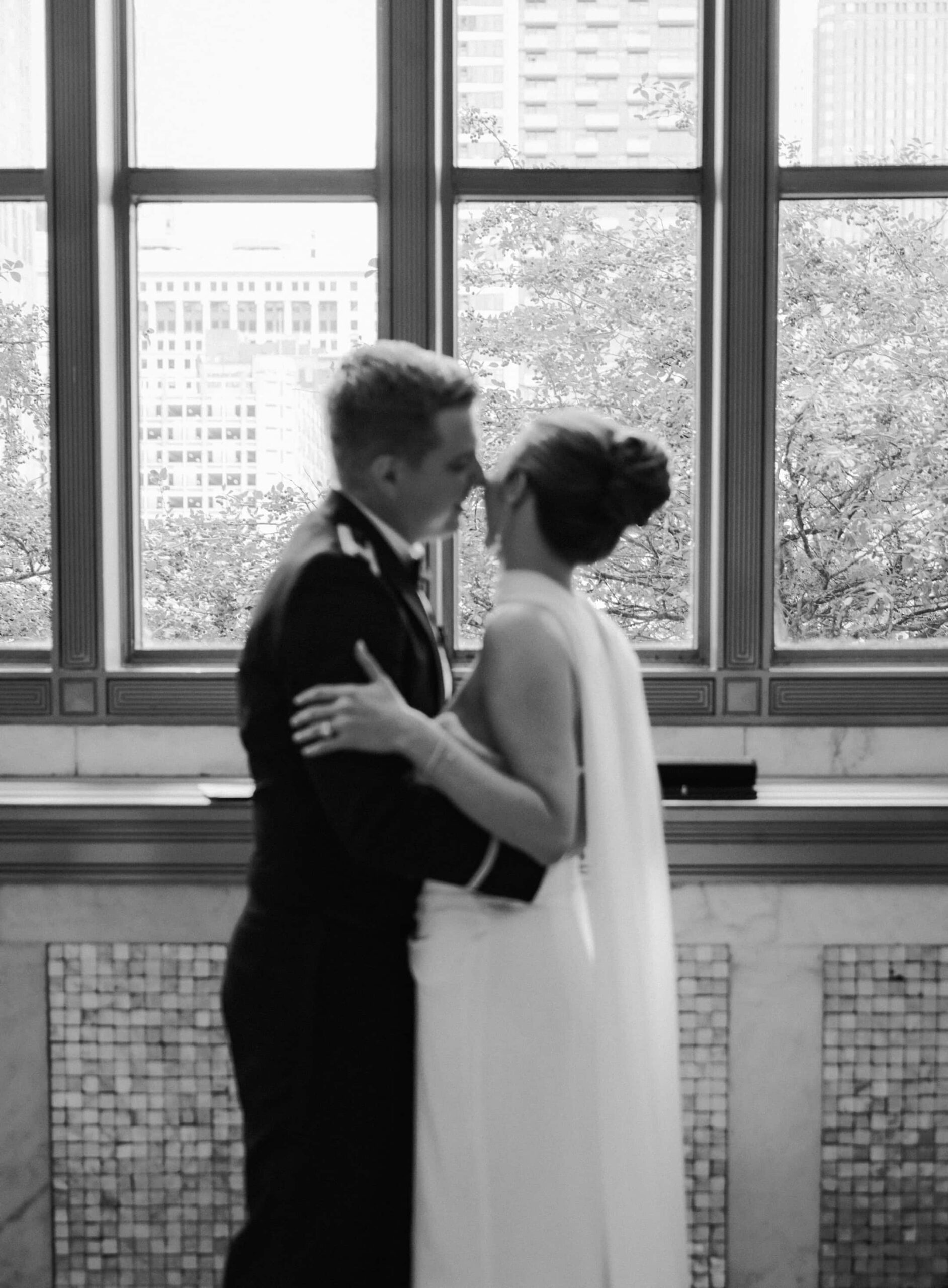 A blurry, out of focus silhouette of a bride and groom in front of a window in a historic Chicago wedding venue.