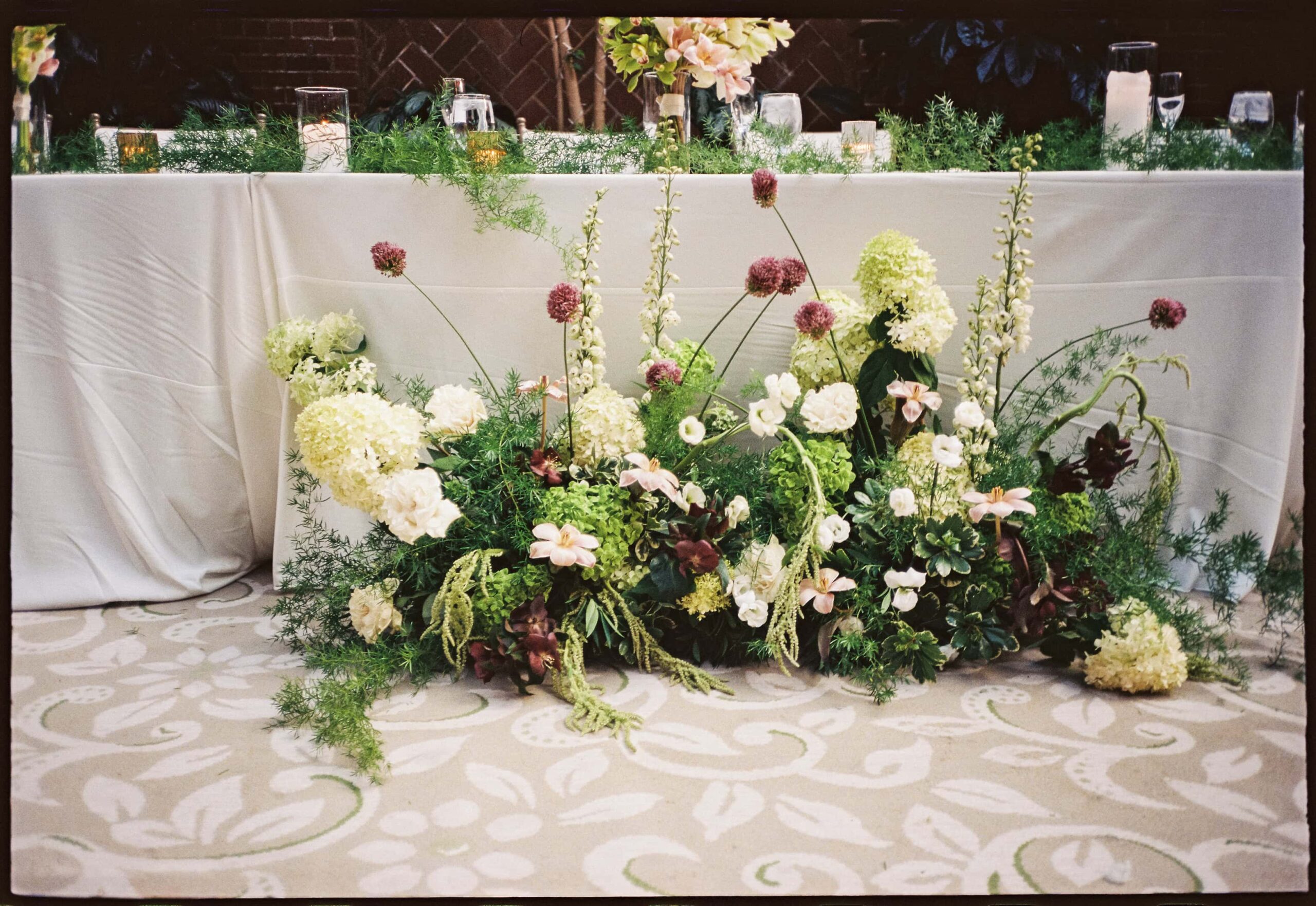 A sculptural floral arrangement in a modern green palette.